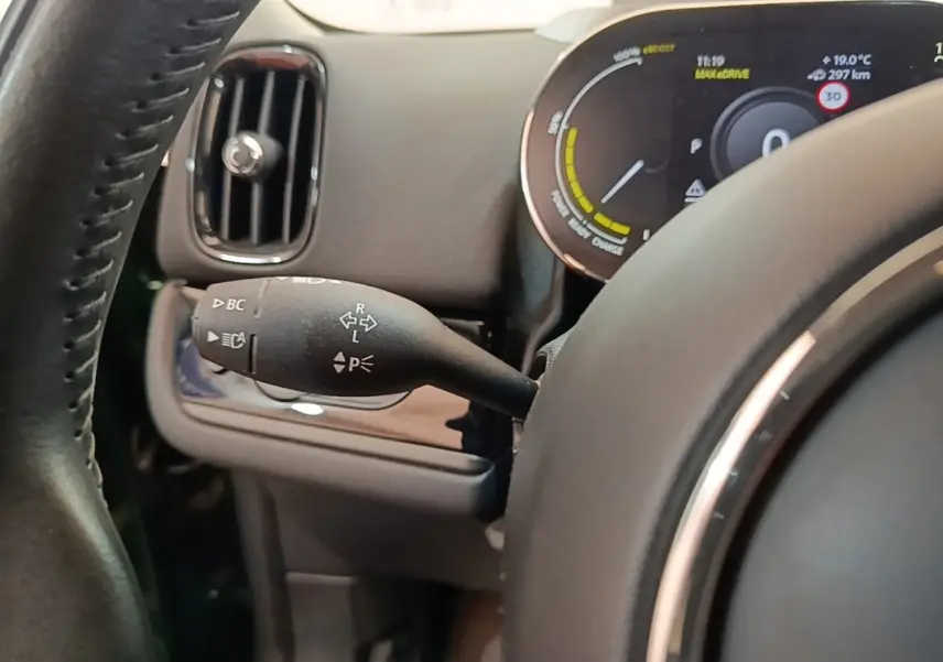 Gros plan sur le combiné d'instruments et la commande de clignotant à gauche du volant dans un MINI Countryman gris clair.