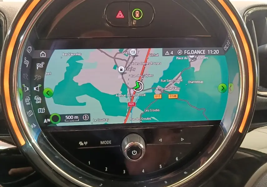 Vue rapprochée de l'écran tactile central du MINI Countryman gris clair affichant la navigation avec anneau lumineux orange.