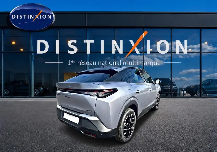 Vue 3/4 arrière droite du Peugeot 3008 gris Artense avec jantes noires devant un showroom Distinxion.