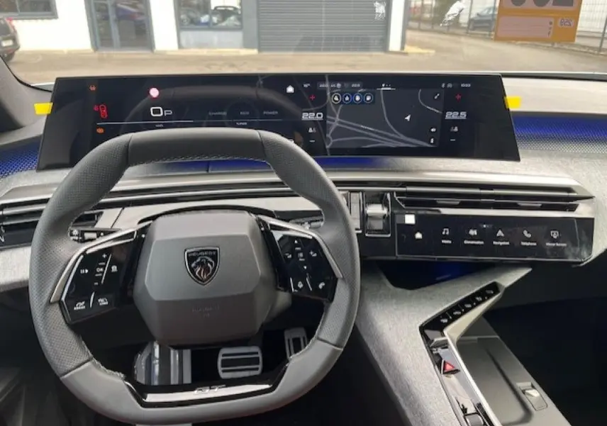 Vue intérieure du poste de conduite du Peugeot 3008 gris Artense 2025, volant cuir multifonction et écran tactile panoramique.