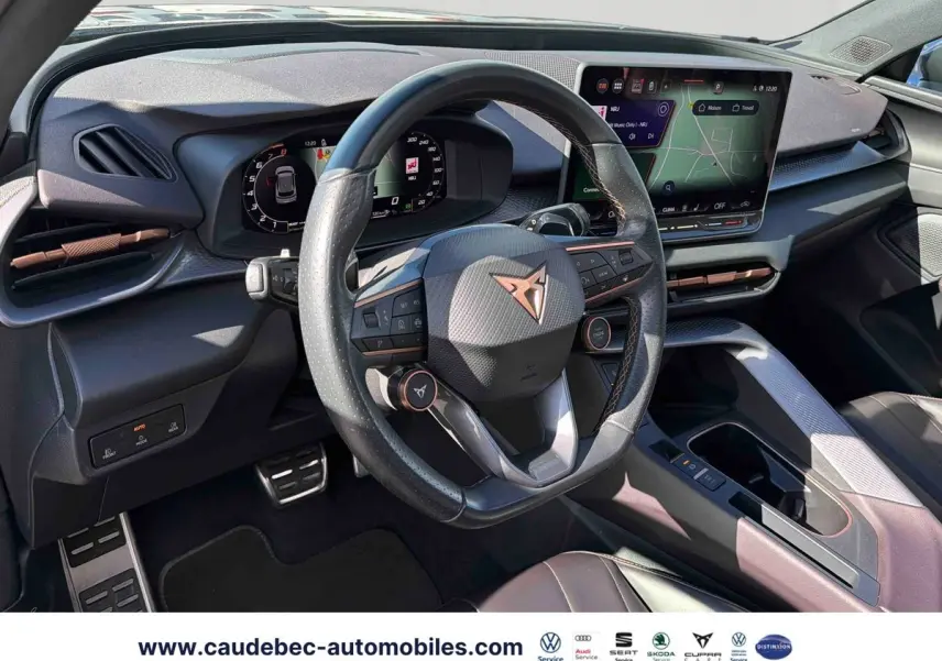 Vue intérieure du poste de conduite du CUPRA Terramar 2024, volant cuir noir avec logo cuivré et tableau de bord digital.