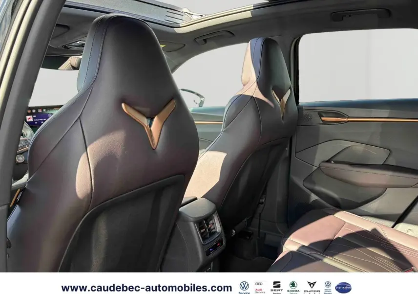 Vue intérieure arrière du CUPRA Terramar noir, sièges baquets cuir avec logos embossés et toit ouvrant panoramique.