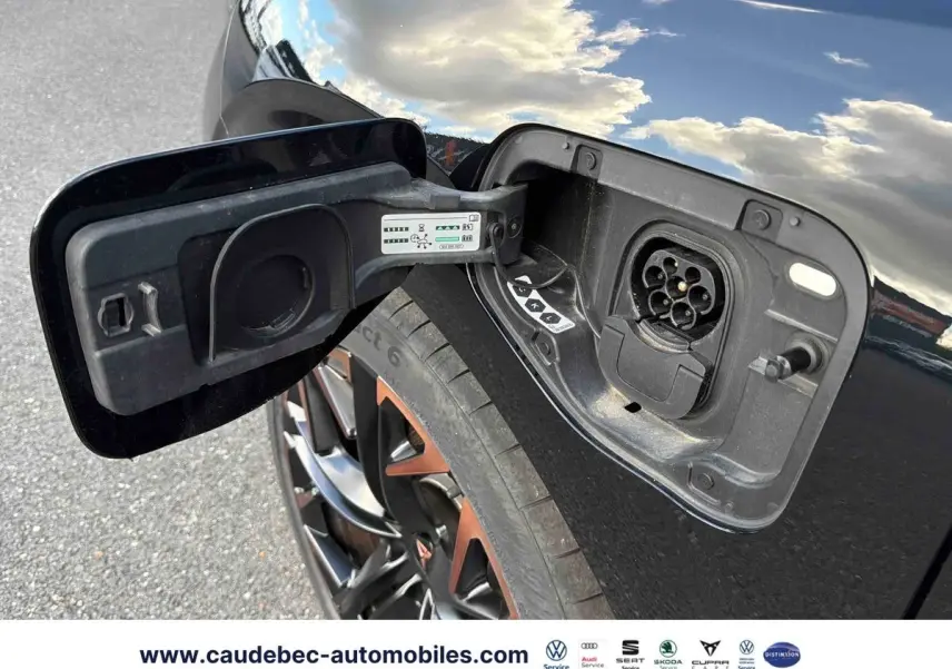 Prise de recharge ouverte côté gauche d’une CUPRA Terramar noire, jante alliage 20 pouces avec accents cuivrés visible.