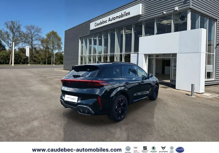 Vue 3/4 arrière droite du CUPRA Terramar noir, avec jantes exclusives et feux arrière LED, devant un showroom.