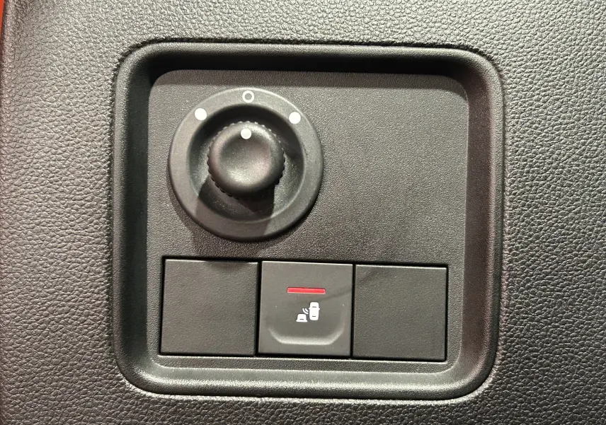 Gros plan sur le bouton de verrouillage centralisé et réglage des rétroviseurs du tableau de bord noir du Dacia Duster 2022.