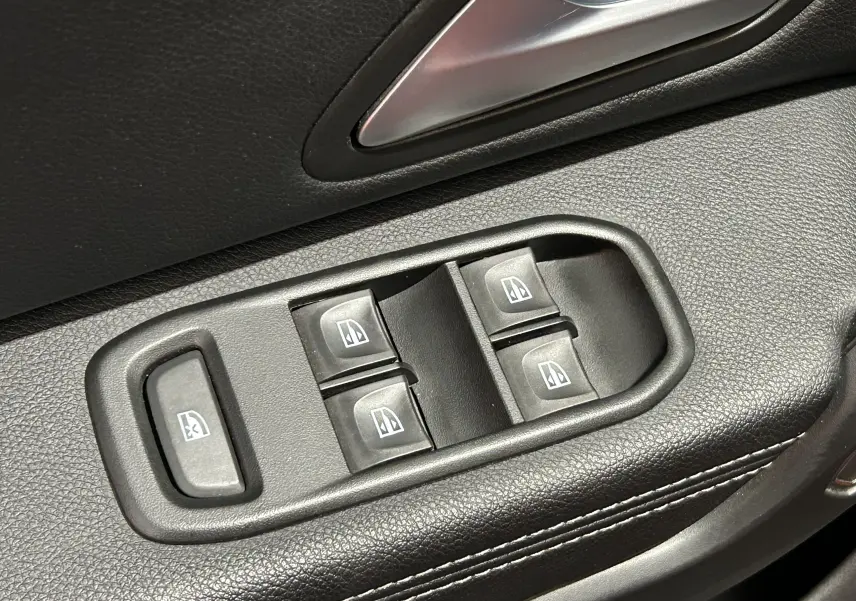 Gros plan sur les commandes électriques des vitres côté conducteur du Dacia Duster 2022, intérieur noir texturé.