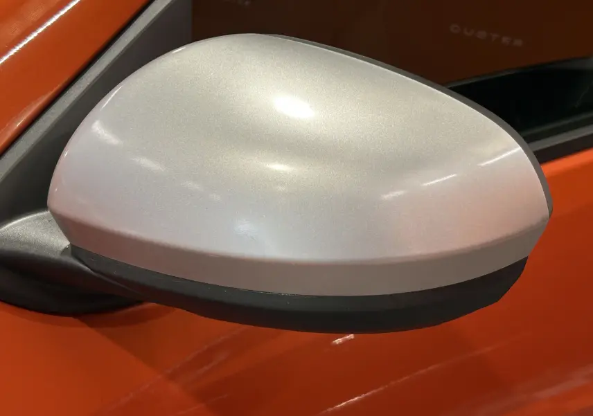 Rétroviseur latéral argenté sur porte orange Arizona d'un Dacia Duster DCI 115 Journey 4WD 2022.