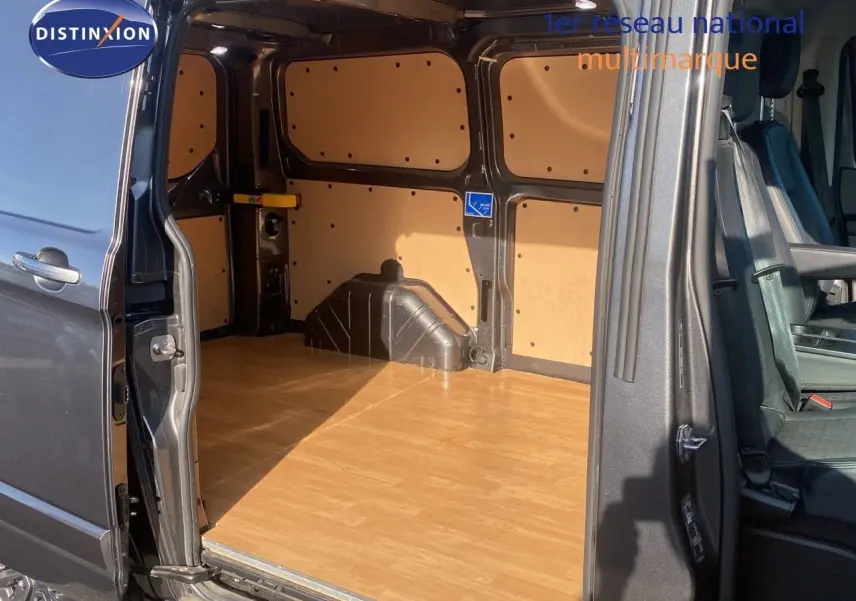 Vue latérale du fourgon Ford Transit Custom gris magnetic 2023, porte coulissante ouverte montrant l'espace de chargement boisé.