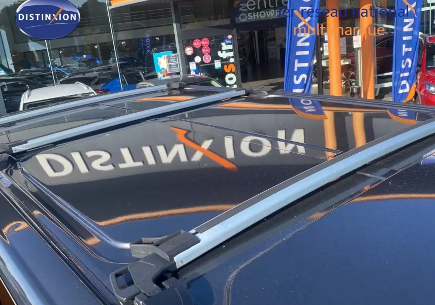 Vue rapprochée du toit gris magnetic du Ford Transit Custom avec barres de toit et reflet du logo Distinxion.