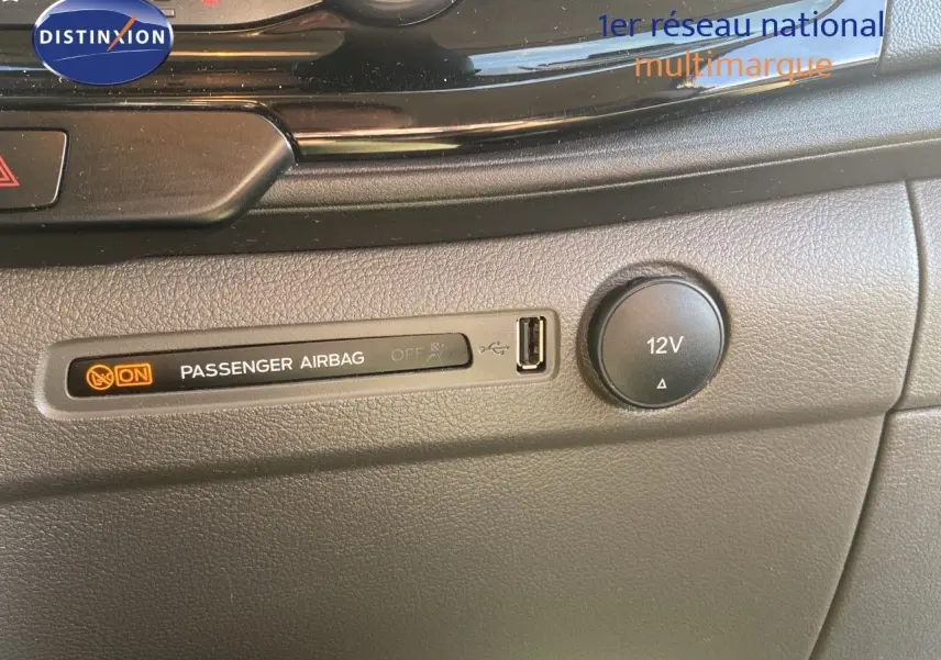 Détail du tableau de bord du Ford Transit Custom gris, montrant l'indicateur airbag passager et une prise 12V.
