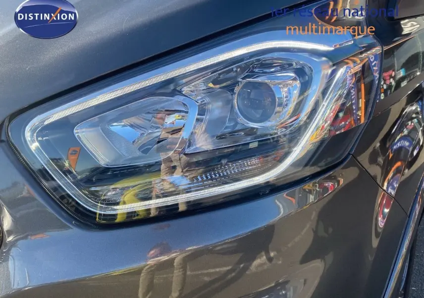 Gros plan sur le phare avant droit du Ford Transit Custom gris magnetic, soulignant ses lignes modernes et précises.