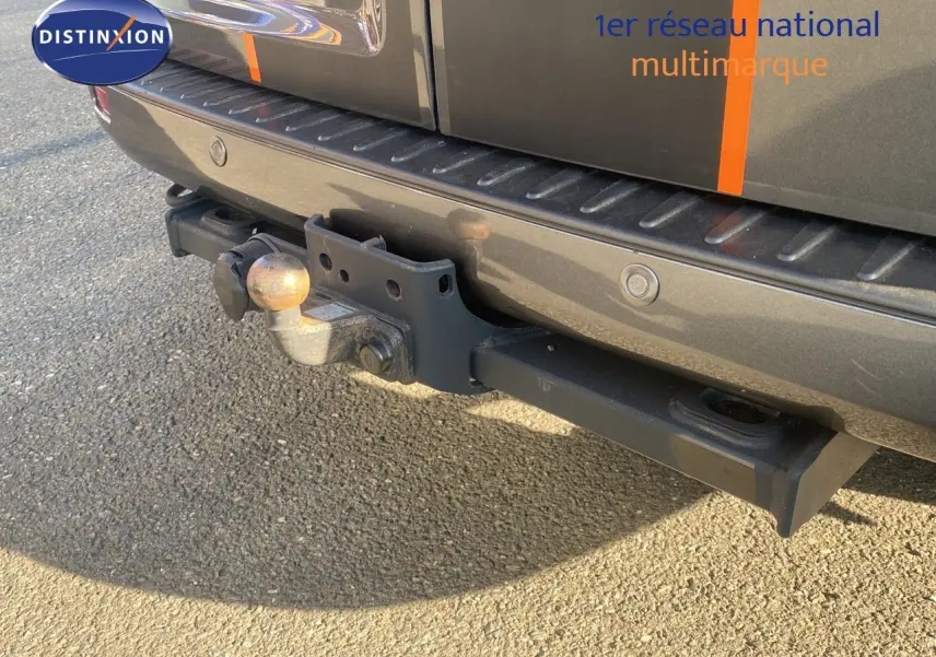 Gros plan sur l'attelage arrière d'un Ford Transit Custom gris magnetic avec capteurs de stationnement intégrés.