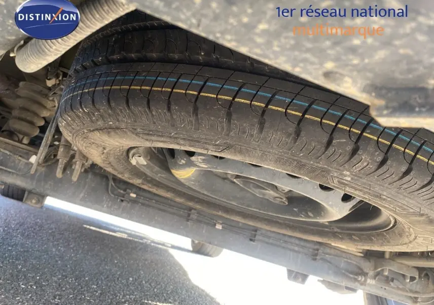 Gros plan sous un Ford Transit Custom gris magnetic 2023 montrant la roue de secours et la suspension arrière.