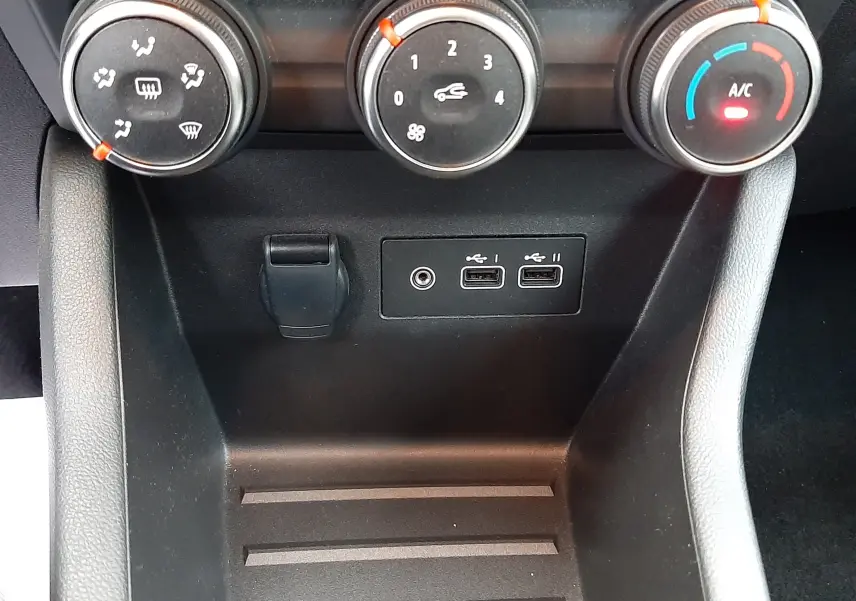 Vue rapprochée des commandes de climatisation et des ports USB du tableau de bord de la Renault Clio V E-Tech gris schiste.