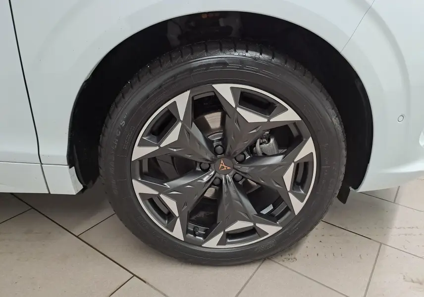 Gros plan sur la jante 19'' Cosmic usinée noire et argent du côté avant droit d'une CUPRA TERRAMAR Blanc Nevada.