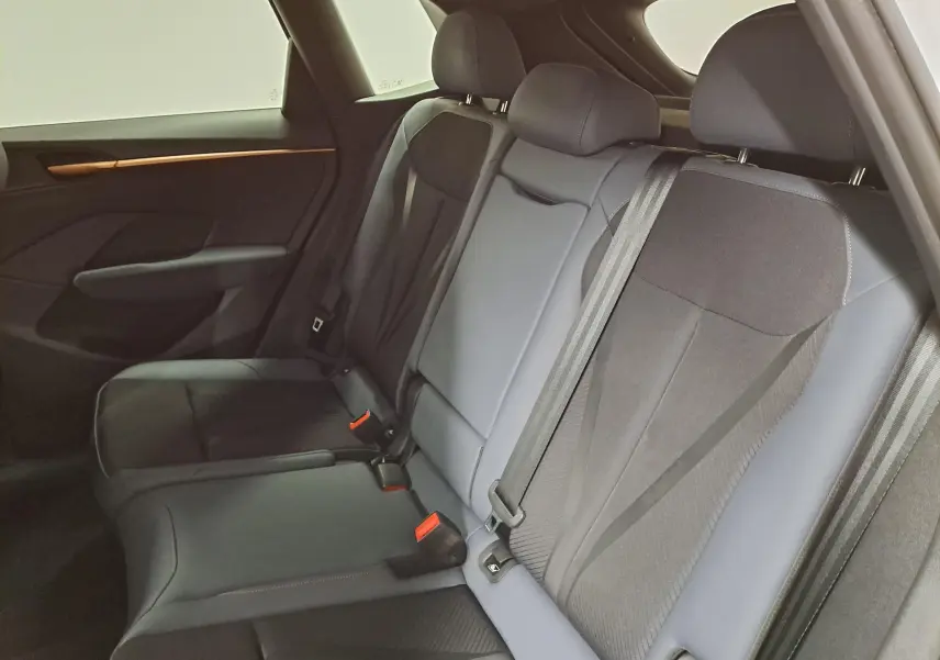 Vue intérieure des sièges arrière du CUPRA TERRAMAR 2025, tissu noir avec détails gris et ceinture de sécurité visible.