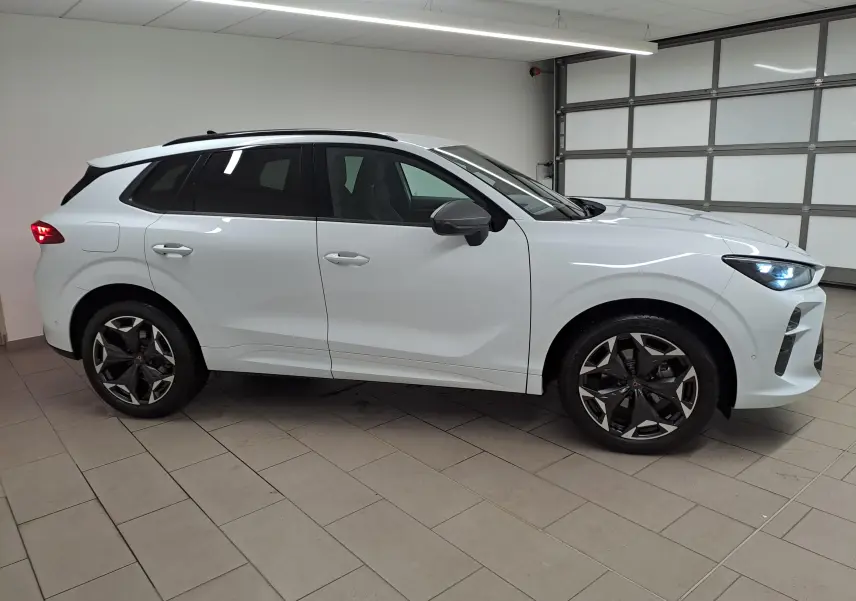 Vue de profil droit du CUPRA TERRAMAR blanc Nevada avec jantes 19'' Cosmic usinées dans un garage.