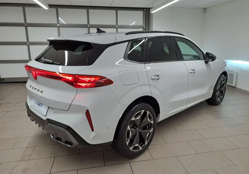 Vue 3/4 arrière droite d'une CUPRA TERRAMAR blanche Nevada avec jantes 19'' Cosmic usinées dans un garage.