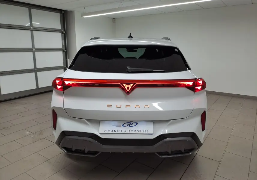 Vue arrière d'une CUPRA TERRAMAR blanche Nevada 2025 avec feux LED continus et logo CUPRA illuminé rouge.