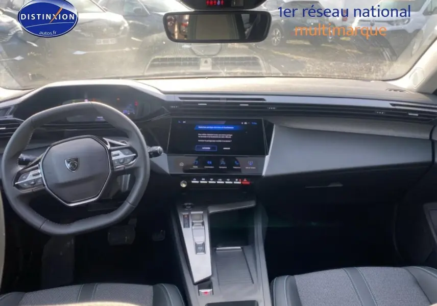 Vue intérieure avant du Peugeot 308 SW gris sellenium, montrant le volant multifonction et l'écran tactile central.