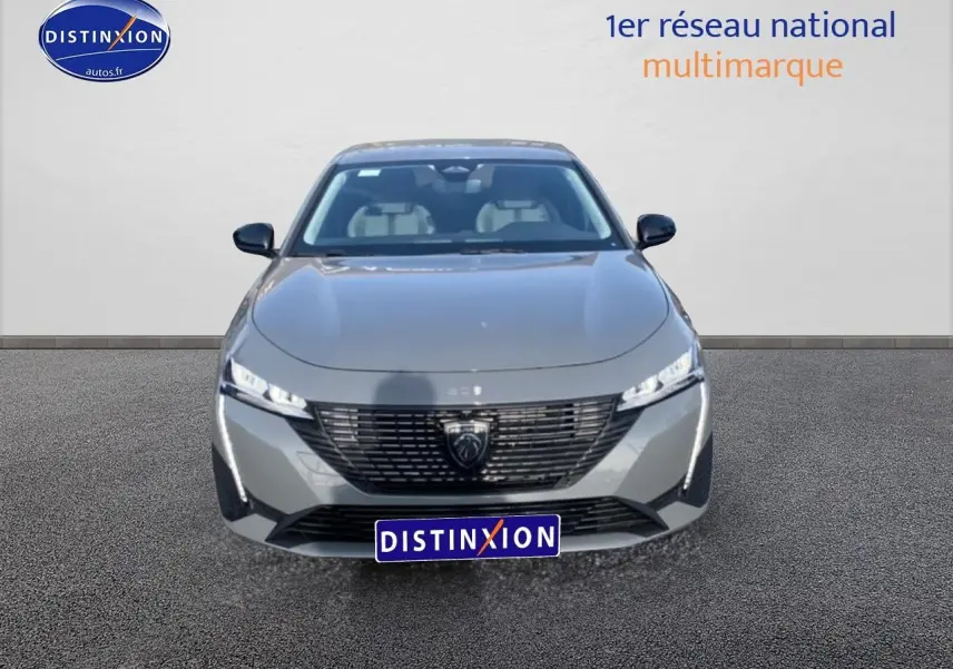 Vue avant d'une Peugeot 308 SW gris sélénite avec calandre noire et phares LED fins allumés.