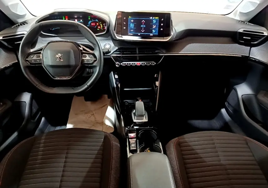 Vue intérieure avant du Peugeot 208 Electrique Active Business 2021, tableau de bord moderne avec écran tactile central et volant cuir.