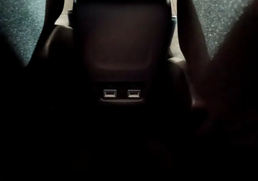Vue rapprochée des ports USB arrière entre les sièges noirs du Peugeot 208 Electrique Active Business blanc.