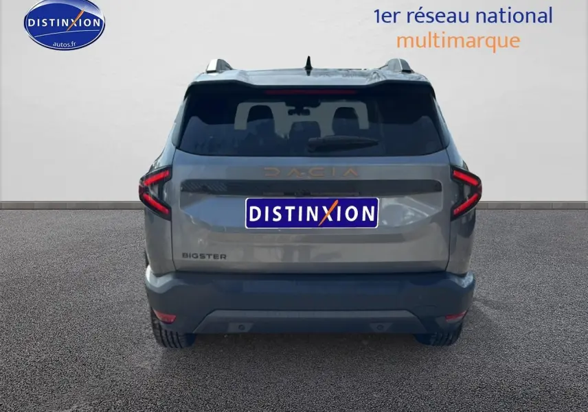 Vue arrière du Dacia Bigster gris schiste avec feux LED en forme de C et hayon électrique visible.