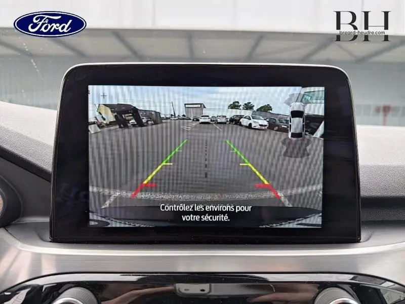 Écran tactile intérieur montrant la caméra de recul du Ford Kuga 2023 noir Agate avec lignes de guidage colorées.