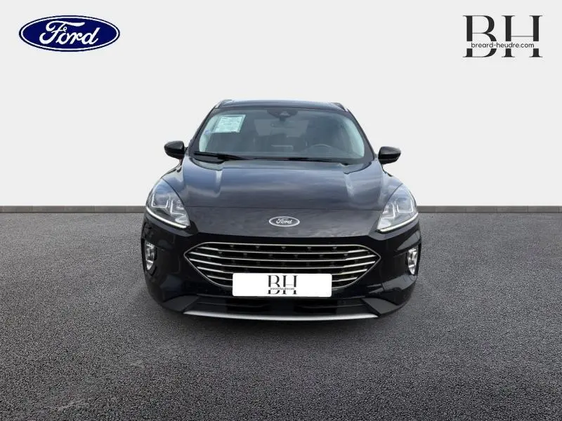 Vue avant d'un Ford Kuga 2023 noir Agate métallisé avec calandre chromée et phares LED distinctifs.