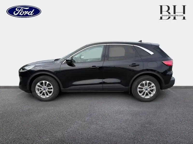 Vue latérale droite d'un Ford Kuga 2023 noir Agate métallisé avec jantes alu et toit ouvrant panoramique visible.