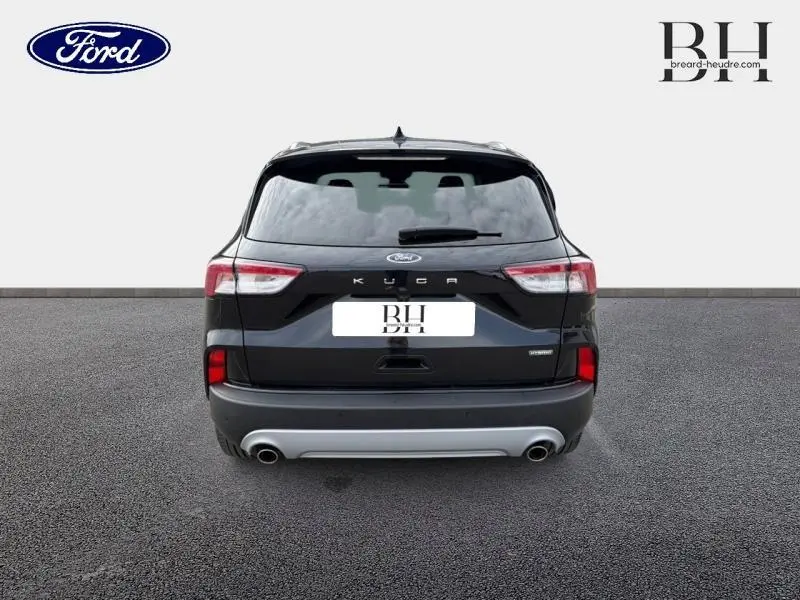 Vue arrière du Ford Kuga 2023 noir Agate métallisé avec double sortie d’échappement et vitres arrière surteintées.