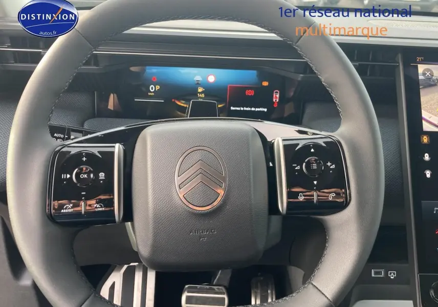 Vue rapprochée du volant noir du Citroën C5 Aircross 2026 avec commandes multifonctions et tableau de bord numérique.