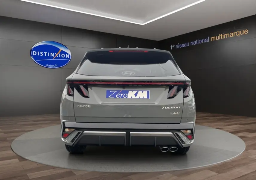 Vue arrière d’un Hyundai Tucson gris foncé hybride avec feux LED distinctifs et double sortie d’échappement.