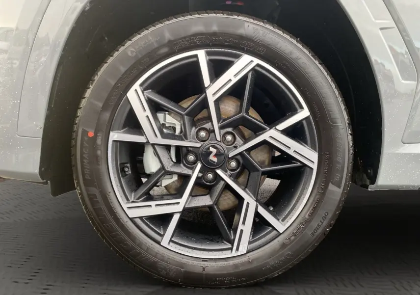 Gros plan sur la roue avant droite du Hyundai Tucson gris foncé avec jante alliage noire et argent N Line.