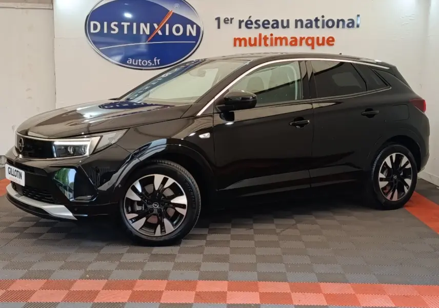 Opel Grandland hybride rechargeable noir en profil droit, avec jantes bicolores et calandre moderne en showroom.