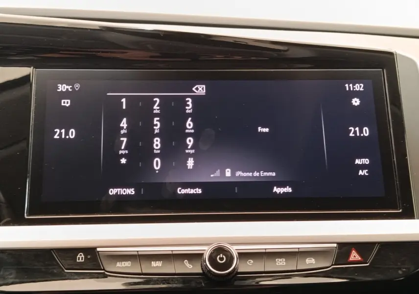 Écran tactile central affichant le clavier téléphonique et la température à 21°C dans l’Opel Grandland Hybride 2023.