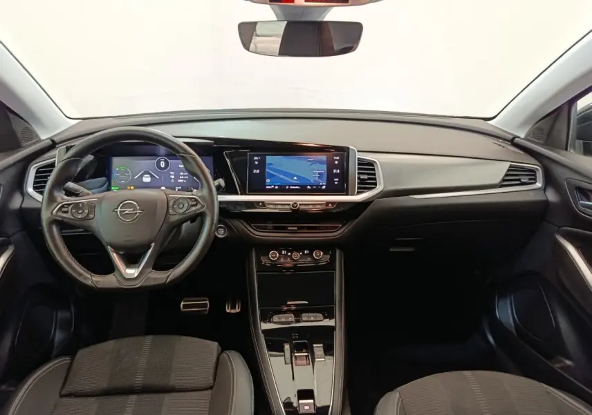 Vue intérieure avant de l'Opel Grandland Hybride 225 ch, tableau de bord moderne avec écran tactile et volant cuir multifonctions.