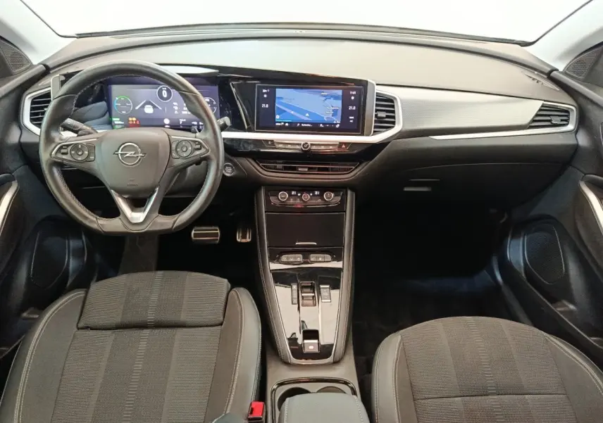 Vue intérieure avant de l’Opel Grandland hybride 2023, tableau de bord noir avec écran tactile central et volant cuir multifonctions.