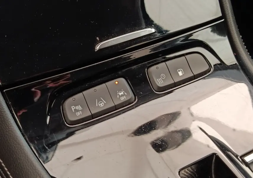 Gros plan sur les boutons de commande noirs brillants du tableau de bord central de l’Opel Grandland hybride 2023.