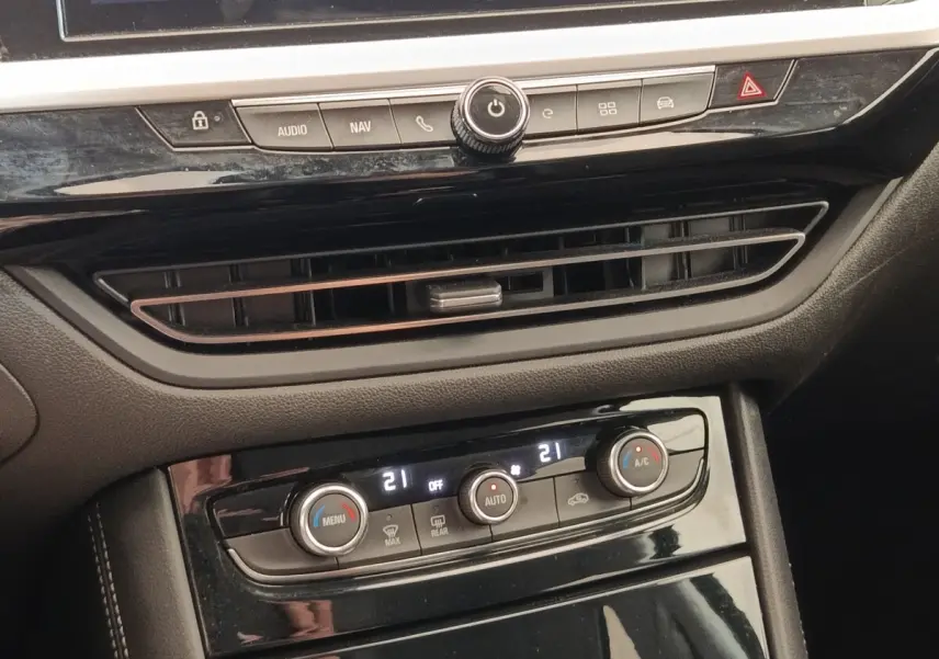 Vue rapprochée de la console centrale noire de l’Opel Grandland 2023, avec commandes climatisation digitale et ventilation.