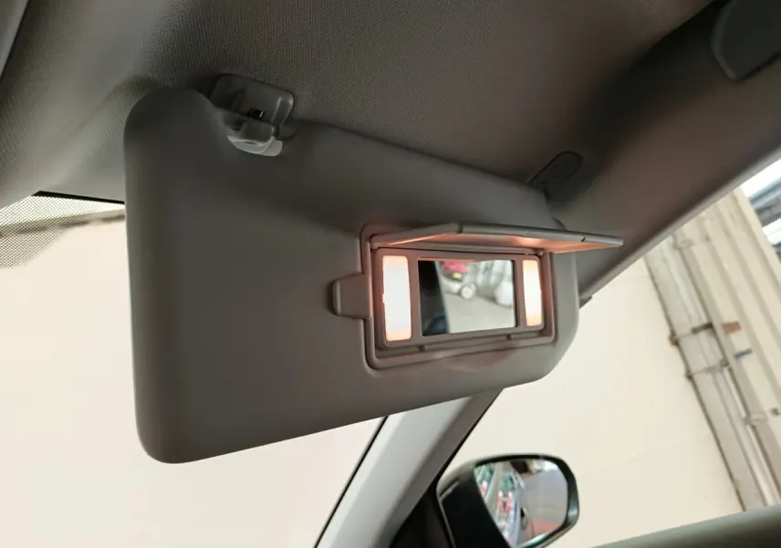 Détail du pare-soleil côté conducteur avec miroir éclairé dans l’habitacle clair de l’Opel Grandland noir.