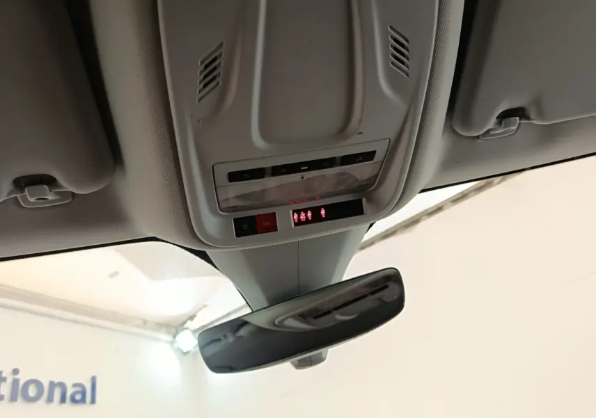 Vue intérieure du plafond avant de l'Opel Grandland noir, montrant le miroir intérieur et les commandes SOS et éclairage.