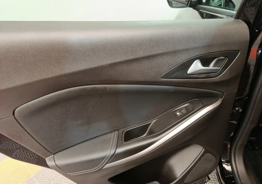 Vue rapprochée de la porte avant droite noire de l’Opel Grandland hybride 2023, avec poignée alu et commandes vitres.