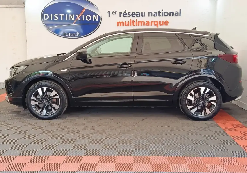 Profil droit d’un Opel Grandland hybride rechargeable noir 2023, avec jantes alliage bicolores et vitres teintées.