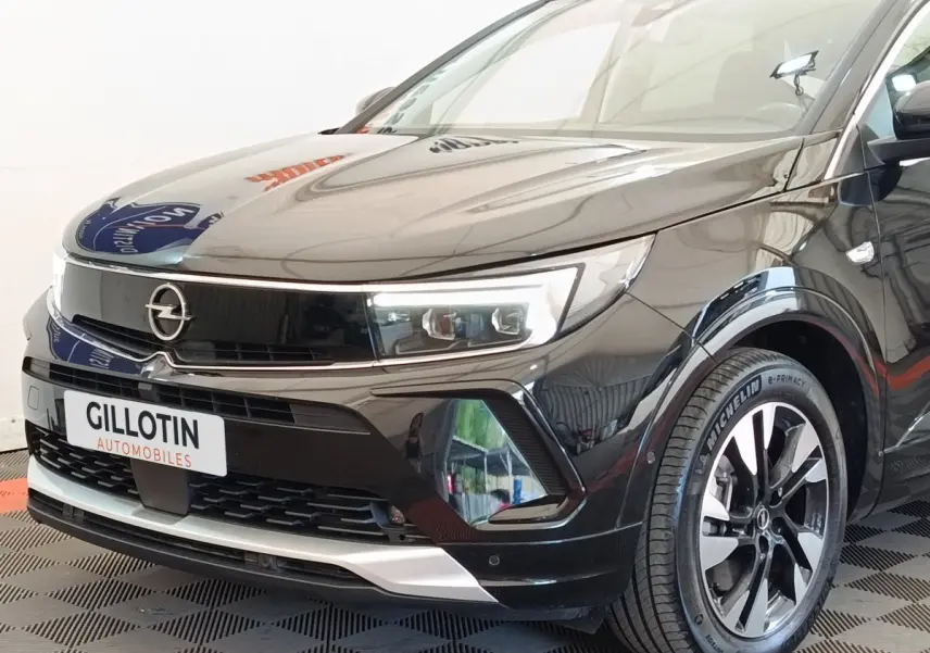 Vue 3/4 avant droit de l’Opel Grandland noir hybride 225 ch avec phares LED et jantes alliage distinctives.