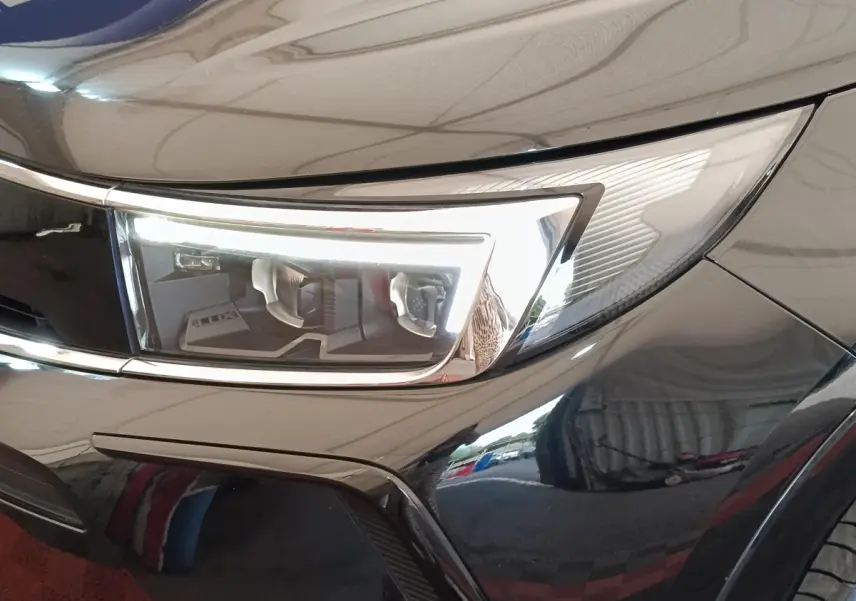 Gros plan sur le phare avant droit du SUV Opel Grandland noir brillant, soulignant ses lignes modernes et épurées.