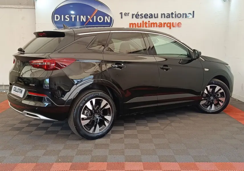 Opel Grandland hybride noir en profil droit, avec jantes alliage bicolores et feux arrière LED visibles.