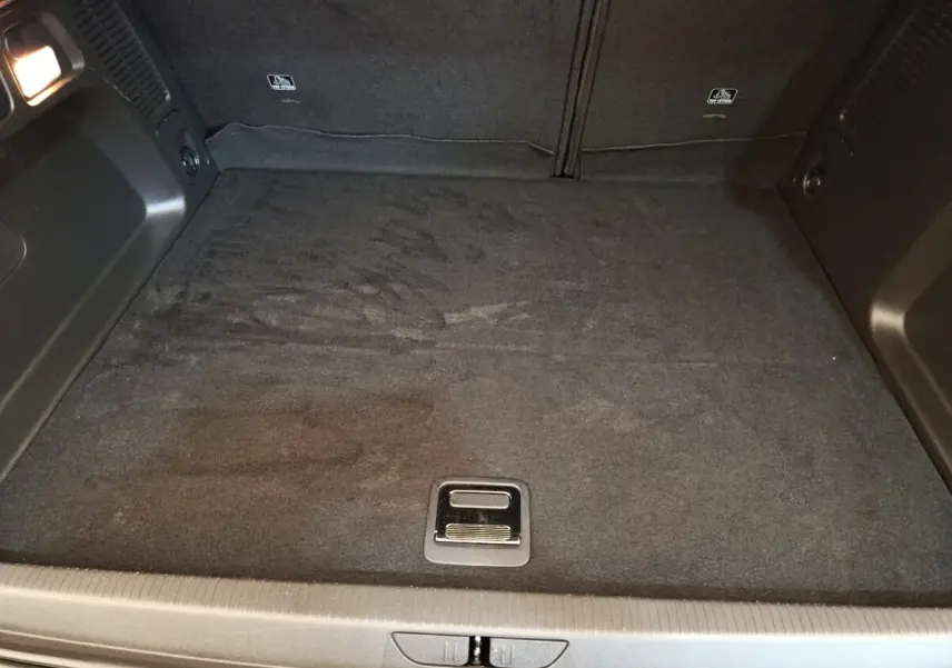 Vue plongeante sur le coffre spacieux et noir de l’Opel Grandland Hybride 225 ch, avec plancher plat et poignée centrale.