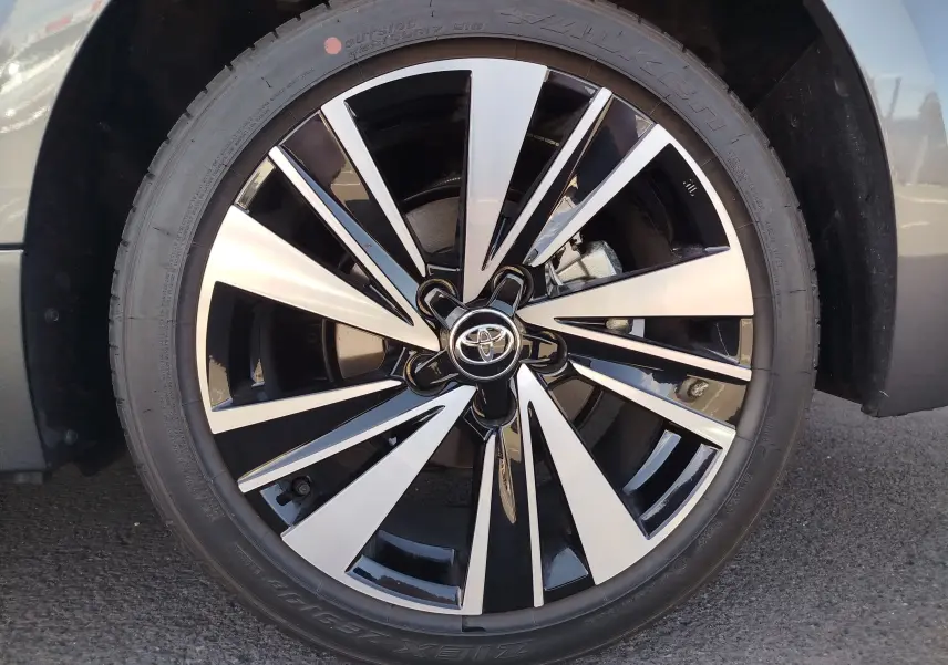 Gros plan sur la jante bi-ton noire et argentée d’une Toyota Corolla Touring Sport gris Atlas, roue avant droite.